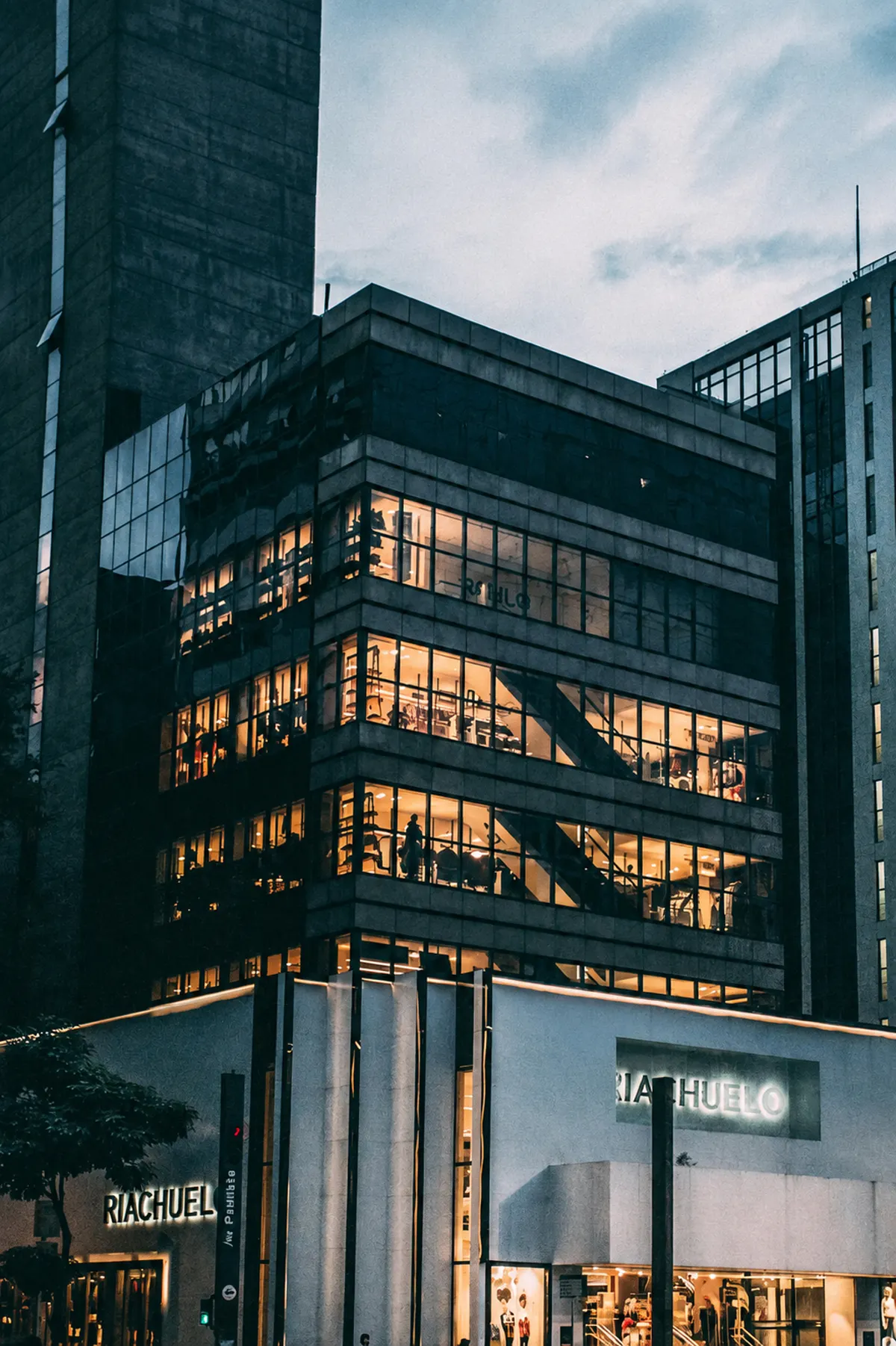Multi-story commercial building lit up at dusk
